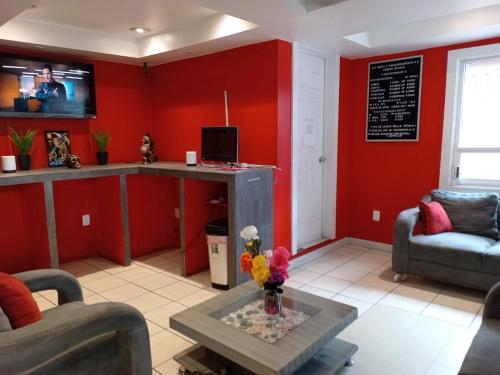 a living room with red walls and a table at HOTEL PUERTO MEXICO 2 in Mexico City