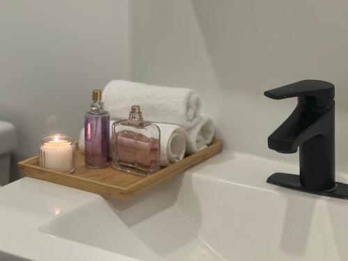 a bathroom sink with a tray with towels and candles at Fancy house in Newmarket