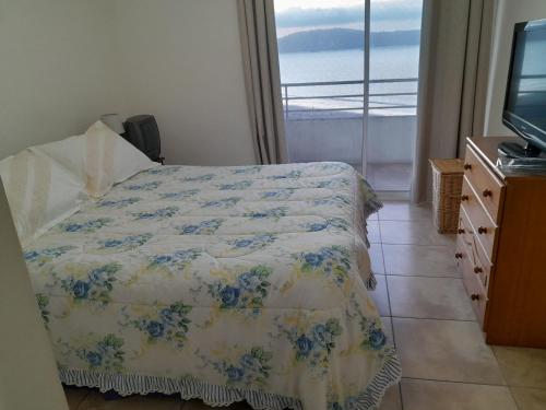 a bedroom with a bed and a tv and a window at Hermosa Vista al Mar in Coquimbo