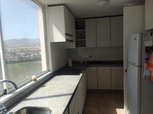 a kitchen with a window and a sink and a refrigerator at Hermosa Vista al Mar in Coquimbo