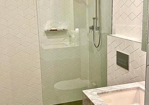 a bathroom with a shower with a glass door at Sydney Cosmopolitan CBD Apartment in Sydney