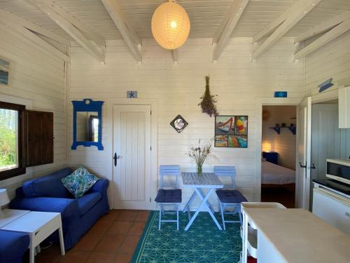 a living room with a blue couch and a table at Rustic Cabin Tarifa 4 guests 10 minutes to beach in Tarifa