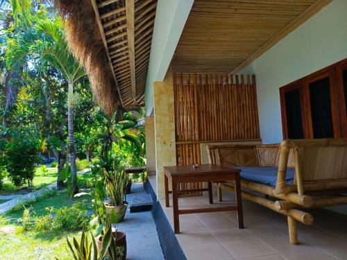 a bedroom with a bed and a wooden table at Mengalung Bungalow in Kuta Lombok