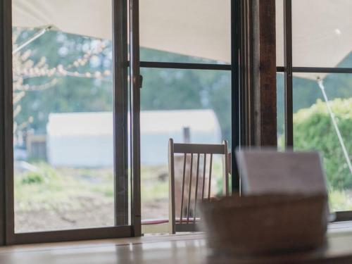 una mesa con una silla frente a una ventana en "八ヶ岳山麓の小さな家", en Hara