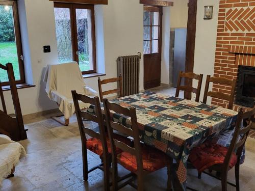 une salle à manger avec une table, des chaises et une cheminée dans l'établissement Gîte typique avec étang privé, linge et ménage inclus, Wi-Fi et animaux gratuits - FR-1-591-378, à Rosnay