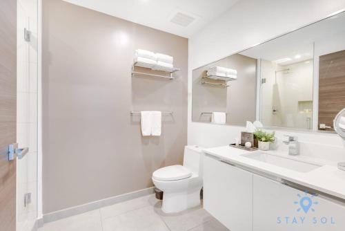 a bathroom with a toilet and a sink and a mirror at Costa Hollywood Beach in Hollywood