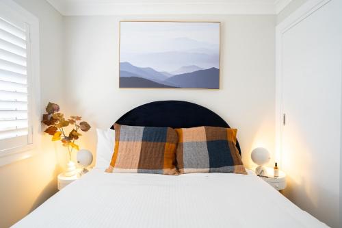 a bedroom with a white bed with two pillows at The Clinton in Orange