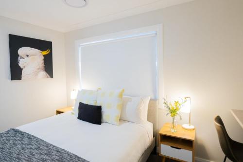 a bedroom with a white bed and a desk at The Clinton in Orange