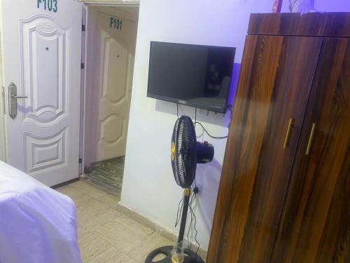 a bedroom with a room with a fan and a tv at De Emeritus Courtyard in Kubwa