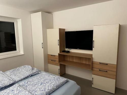 a bedroom with a bed and a flat screen tv at Wohnung 55m2 Top Ausstattung in Haag am Hausruck