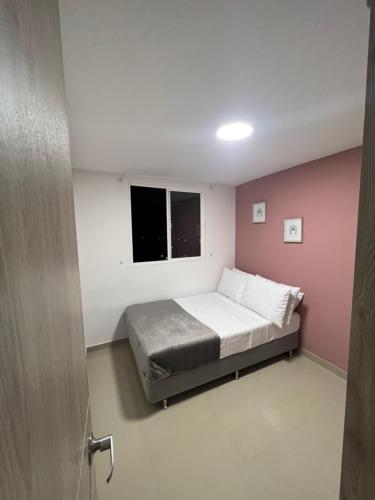 a small bedroom with a bed and a window at CALI Acogedor y Completo, Apto cerca de Jardin plaza, con piscina, parqueadero y aire acondicionado in Cali