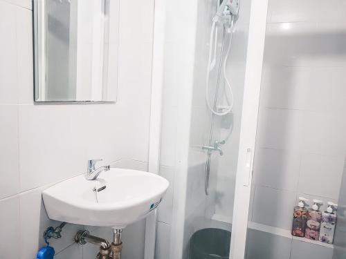 biała łazienka z umywalką i prysznicem w obiekcie Affordable 2 Bed Condo Rental in Davao City with Wifi & Netflix, Swimming Pool, Gym & Billiard Hall w mieście Davao