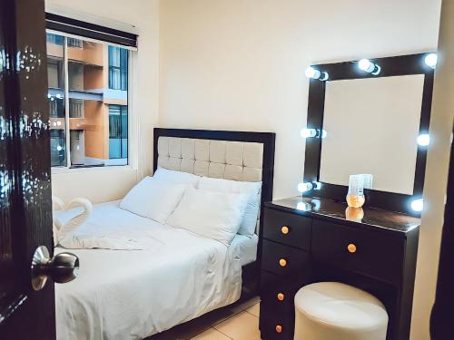 a bedroom with a bed with a mirror and a dresser at Affordable 2 Bed Condo Rental in Davao City with Wifi & Netflix, Swimming Pool, Gym & Billiard Hall in Davao City