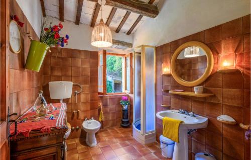 W łazience znajduje się umywalka, toaleta i lustro. w obiekcie 4 Bedroom Beautiful Home In Acqualagna w mieście Acqualagna