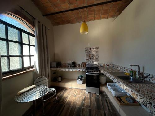 a kitchen with a sink and a stove top oven at Casa Moka Amarilla in La Peñita de Jaltemba