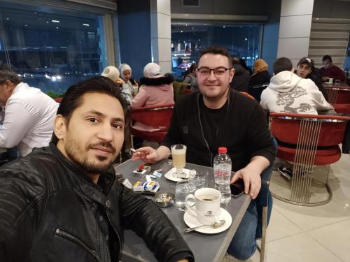 two men sitting at a table in a restaurant at Eyad Pyramids view in Cairo