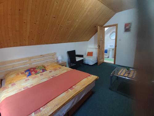 a bedroom with a bed and a wooden ceiling at Privat Mária in Liptovský Ján