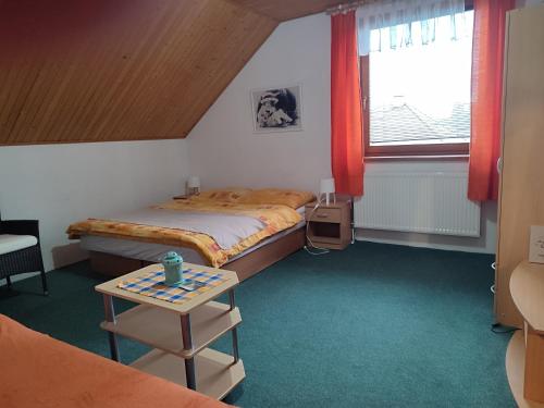 a small bedroom with a bed and a table at Privat Mária in Liptovský Ján