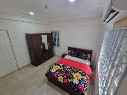 a bedroom with a bed with a red blanket at 2 bedrooms Apartment, Hillview of Accra in Kwabenya