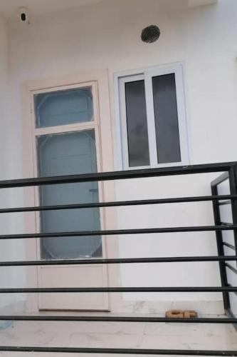 a balcony with a door and windows on a house at 2 bedrooms Apartment, Hillview of Accra in Kwabenya