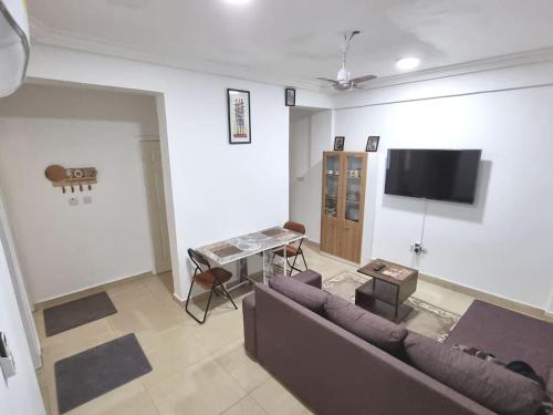 a living room with a couch and a flat screen tv at 2 bedrooms Apartment, Hillview of Accra in Kwabenya