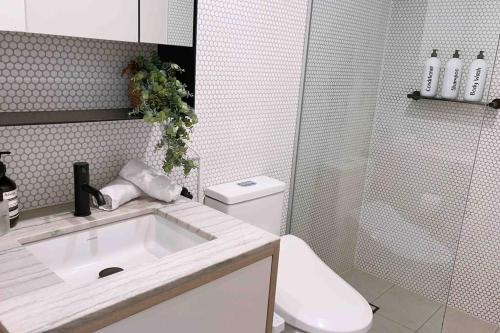 bagno bianco con servizi igienici e lavandino di Award winning designer complex – Cantala a Melbourne