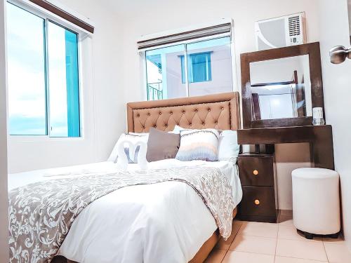 sypialnia z dużym łóżkiem i lustrem w obiekcie Affordable 2 Bed Condo Rental in Davao City with Wifi & Netflix, Swimming Pool, Gym & Billiard Hall w mieście Davao