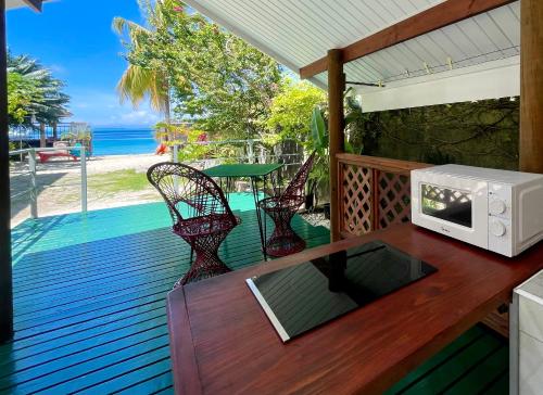 a wooden deck with a microwave on a table at Huahine Beach House in Fare