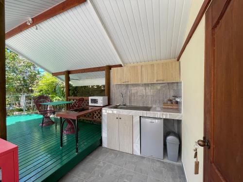 a kitchen on a deck with a table and a table at Huahine Beach House in Fare
