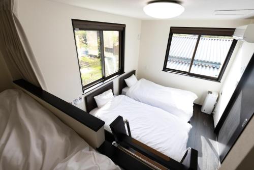 a small room with two beds and a window at Holiday home Furinkazan 風林火山 in Fujikawaguchiko