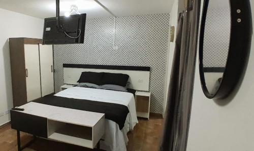 een slaapkamer met een bed en een tv. bij 01 Upper 109 in Curitiba