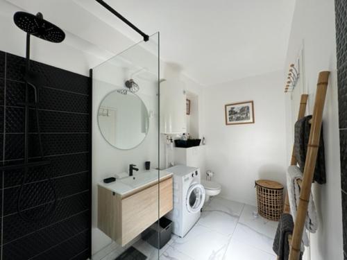 uma casa de banho com um lavatório e uma máquina de lavar roupa em Anse des Caraïbes em Les Trois-Îlets