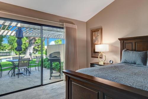 a bedroom with a bed and a patio with a table at RC942 - Racquet Retreat - Meredith Lodging in Rancho Mirage