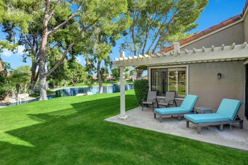 a patio with blue chairs and a pool at RC942 - Racquet Retreat - Meredith Lodging in Rancho Mirage