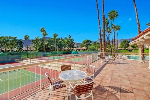 a tennis court with a table and chairs at RC942 - Racquet Retreat - Meredith Lodging in Rancho Mirage