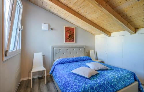 a bedroom with a bed with a blue comforter at Beautiful Home In Marotta With Kitchen in Marotta
