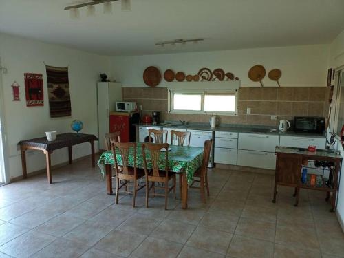 a kitchen with a table and a table and chairs at Hermosa casa de campo y bosques in Toay