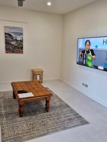 a room with a table and a tv on a wall at Koopalanda Dreaming in Vivonne Bay