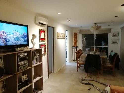 een woonkamer met een televisie en een eetkamer bij ROMFER in San Eduardo del Mar