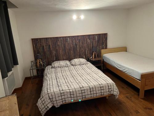 sypialnia z 2 łóżkami i drewnianym zagłówkiem w obiekcie Maison de village - Monteux centre - Provence w mieście Monteux