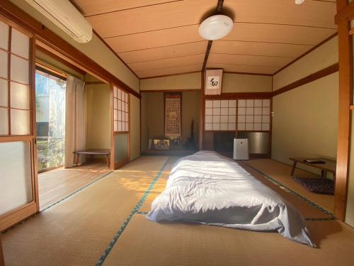 Una habitación con una cama en el medio. en ゲストハウス アルベルゲ Guesthouse ALBERGUE SAKURA, en Sukumo