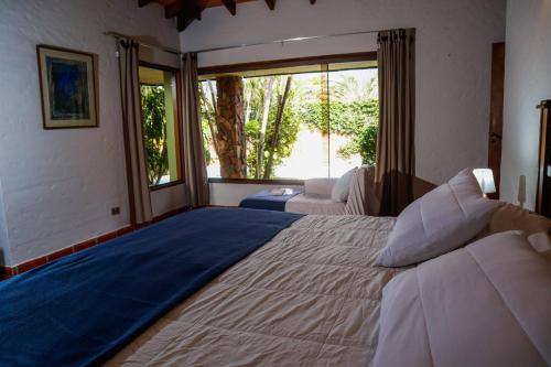 a bedroom with two beds and a large window at Villa Adela in Luque