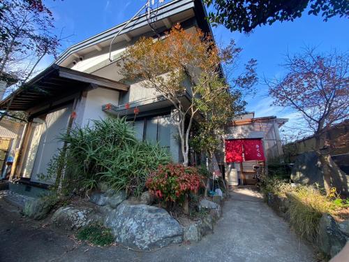 une maison avec quelques plantes devant elle dans l'établissement ゲストハウス アルベルゲ Guesthouse ALBERGUE SAKURA, à Sukumo