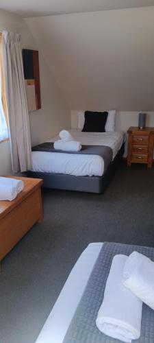a hotel room with two beds and two night stands at 1 St James in Hanmer Springs