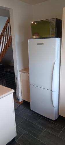 a white refrigerator with a microwave on top of it at 1 St James in Hanmer Springs