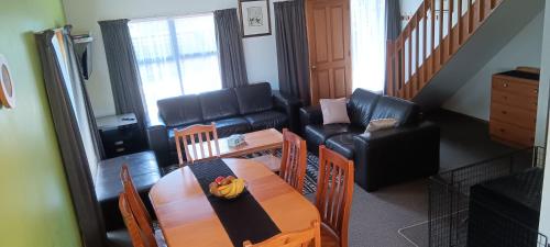 a living room with a table and a couch at 1 St James in Hanmer Springs