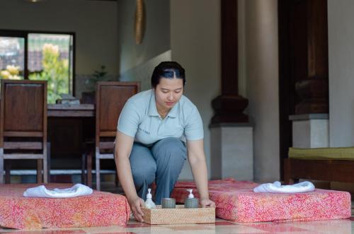 kobieta klęcząca na szczycie dwóch pudeł w obiekcie Ubud Heaven Penestanan w mieście Ubud