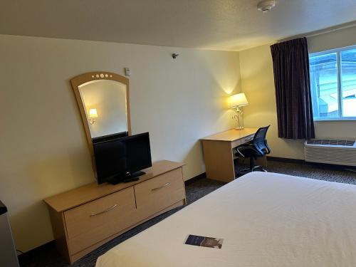 a hotel room with a bed and a mirror at Baymont by Wyndham Lawrenceburg in Lawrenceburg