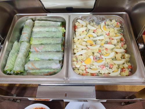 カットバ島にあるLang Chai Hotel Cat Baの冷蔵庫の中にある2つの金属トレイに入った食品