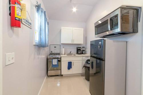 a kitchen with a stainless steel refrigerator and white cabinets at Mango Delight (Mercy's Place) in Buckleys